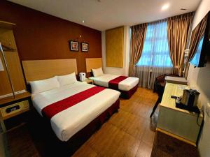 a hotel room with two beds and a television at Eight Days Boutique Hotel - Permas Jaya in Johor Bahru