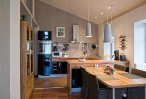 a kitchen with a wooden table with chairs and a stove at Apartment Abendsonne Mit Eigener Terrasse in Klein Meckelsen
