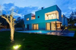 una casa azul con una piscina frente a ella en Designvilla Mit Dachterrasse Und Panoramablick, en Karigador