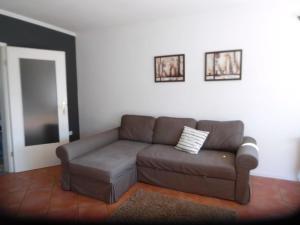 a living room with a brown couch and two pictures on the wall at Ferienhaus Mit Garten Und Stellplatz in Großenaspe