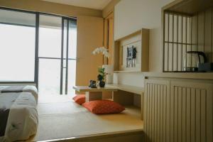 ein Schlafzimmer mit einem Bett und einem Tisch und einem Fenster in der Unterkunft Lynn Times Thanh Thuỷ Hotels & Resorts in Xuân Vi