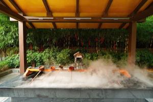 eine Person, die unter einer Tarnung steht und Rauch herauskommt. in der Unterkunft Lynn Times Thanh Thuỷ Hotels & Resorts in Xuân Vi