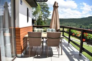 a patio with a table and chairs on a balcony at Chata s výhledem do údolí Frymburk, Náhlov in Frymburk