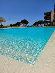 a swimming pool with blue water and white sand at Health Village Apartments in Cascais