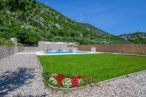a garden with a swimming pool and some flowers at Villa Elin in Seoca