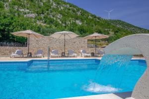 a swimming pool with chairs and umbrellas at Villa Elin in Seoca +29 photos