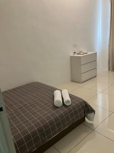 a bedroom with two white towels on a bed at Chicken Little 4-bedroom home with free parking! Available for Business Trip in Kampong Lima Kongsi