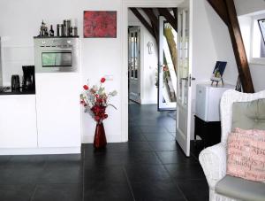 a living room with a vase of flowers on the floor at Markermeerlogies in Bovenkarspel