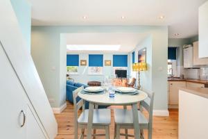 a kitchen and dining room with a white table and chairs at Host & Stay - Blue Bolthole on Vicarage Lane in Rottingdean