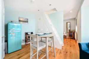 a kitchen with a table and a blue refrigerator at Host & Stay - Blue Bolthole on Vicarage Lane in Rottingdean