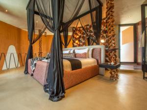 a bedroom with a bed with a canopy at The Ekipa in Okaukuejo +16 photos