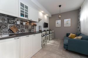 una cucina con armadi bianchi e un divano blu di Familienpension Tina Appartement 7 a Šilo Altre 16 foto