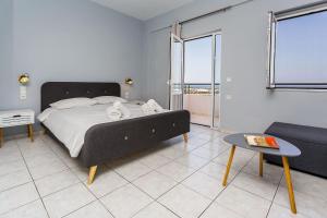 a bedroom with a bed and a couch and a table at Wunderschöne Wohnung In Kato Gouves Mit Parkplatz in Kato Gouves