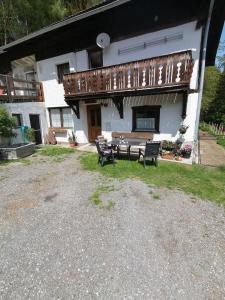 ein Haus mit einer Terrasse und Bänken im Hof in der Unterkunft Ruhig am Waldrand gelegene Wohneinheit in Innsbruck
