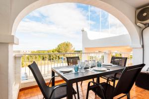 a dining room with a table and chairs on a balcony at Apartamento CASTELLSOL 201 by Mauter Villas in Arenal d'en Castell