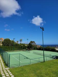 a tennis court with two tennis courts at Health Village Apartments in Cascais