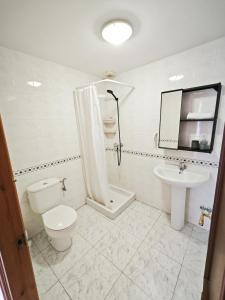 a white bathroom with a toilet and a sink at El Penell Apartament Xaloc in Vilamaniscle