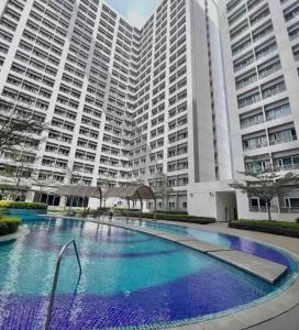 a large swimming pool in front of a large building at Luxury for Less next to BGC and Makati CBD in Manila