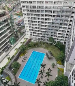 an overhead view of a large building with a swimming pool at Luxury for Less next to BGC and Makati CBD in Manila