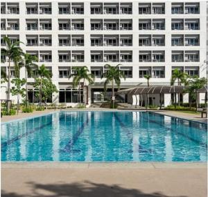 a large swimming pool in front of a building at Luxury for Less next to BGC and Makati CBD in Manila