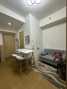 a living room with a table and a couch at Luxury for Less next to BGC and Makati CBD in Manila