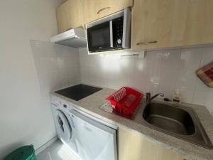 a kitchen with a sink and a washing machine at appartement dans un residence avec piscine - 3254 in Hourtin