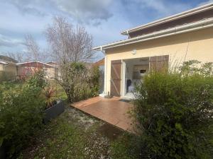 a house with a door open on a patio at appartement dans un residence avec piscine - 3254 in Hourtin