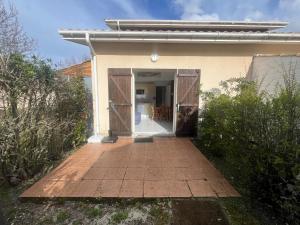 a entry to a house with an open door at appartement dans un residence avec piscine - 3254 in Hourtin +3 photos