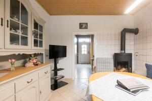 a kitchen with a living room with a fireplace at Ferienwohnung Lüttje Huus 35227 in Neuemoor