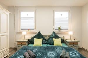 a bedroom with a bed and two windows at Ferienwohnung Lüttje Huus 35227 in Neuemoor