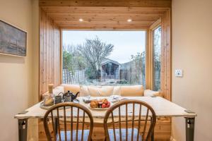 a dining room with a table and a couch at Fen Cottage, Walberswick in Walberswick