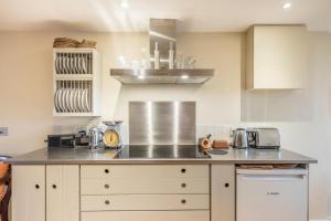 a kitchen with a counter with a stove top oven at Fen Cottage, Walberswick in Walberswick +11 photos