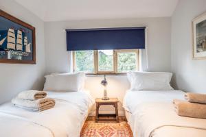 two twin beds in a room with a window at Fen Cottage, Walberswick in Walberswick