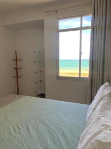 a bedroom with a bed with a view of the ocean at Bela vista a beira mar in Marataizes