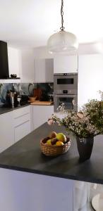 una cocina con una cesta de fruta en la barra en Gîte Saint Benoît sur Loire Val de Sully, en Saint-Benoît-sur-Loire