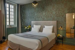a bedroom with a large bed with green walls at Hôtel Littéraire Stendhal et Spa in Nancy
