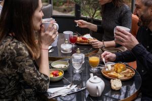 a group of people sitting around a table eating food at Hôtel Littéraire Stendhal et Spa in Nancy