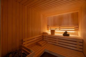 a sauna with a tub in a wooden room at Hôtel Littéraire Stendhal et Spa in Nancy