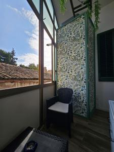 a room with a chair and a window with a view at Sofia's Central Apartment Palermo in Palermo