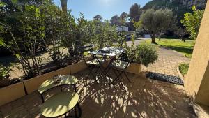 un patio con tavolo e sedie in giardino di Studio tout confort au calme avec jardin proche Cannes a Le Cannet