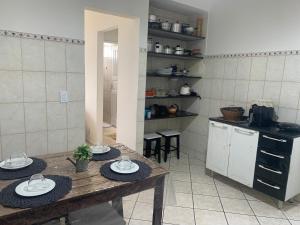 a kitchen with a table with plates on it at Bela vista a beira mar in Marataizes