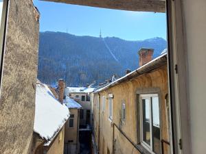 a view from a window of snow covered roofs at Republicii Apartment in Braşov