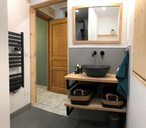 ein Badezimmer mit Waschbecken und Spiegel in der Unterkunft L'Hospitalier in Saint-Antoine + 10 Fotos