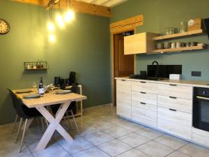 eine Küche mit einem Holztisch und einer Arbeitsplatte in der Unterkunft L'Hospitalier in Saint-Antoine