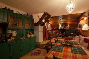 a kitchen with green cabinets and a table in a room at Dandy Villas Agoriani - Chalet Iris- Fireplace - Up to 6 in Eptalofos