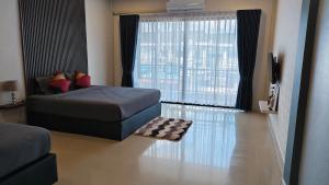 a living room with a couch and a large window at Chani House Hatyai in Hat Yai