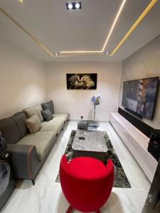 a living room with a couch and a red chair at Meenah luxury homes in Ikeja