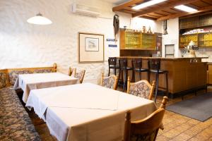 a dining room with two tables and a bar at Hotel Schlüssel in Denkendorf
