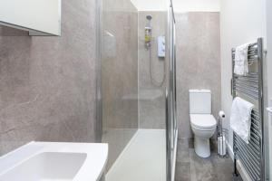 a bathroom with a shower and a toilet and a sink at Little Lammas in Ringstead +13 photos