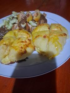 une assiette de nourriture sur une table en bois dans l'établissement Papajamsurfcamp, à Masokut